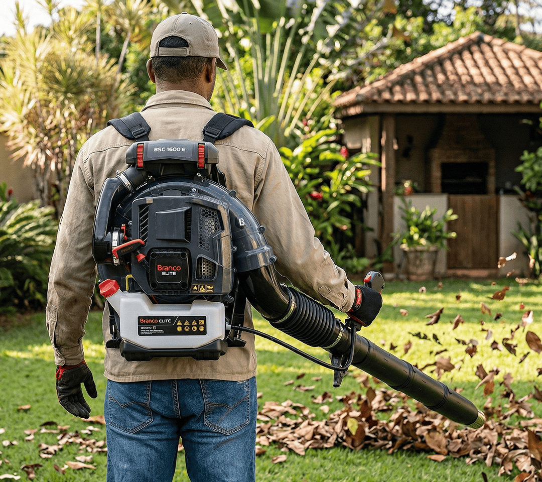 Pessoa utilizando soprador costal Branco Elite BSC 1600 E para reunir folhas secas sobre o gramado. 